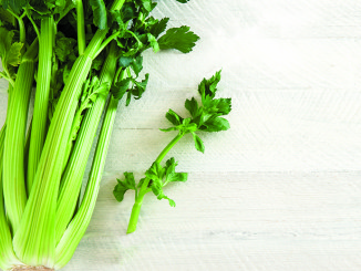 Green celery on the white wooden table