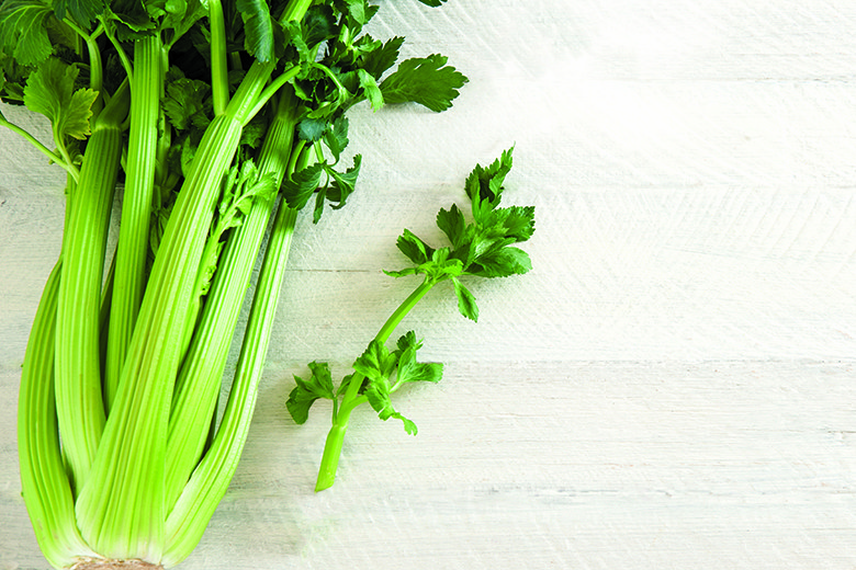 Green celery on the white wooden table