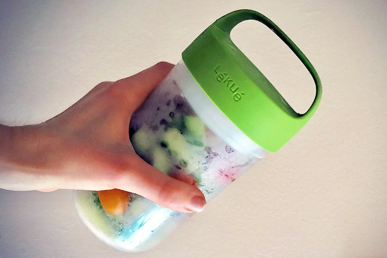 hand holding Lekue Jar To Go filled with veggies