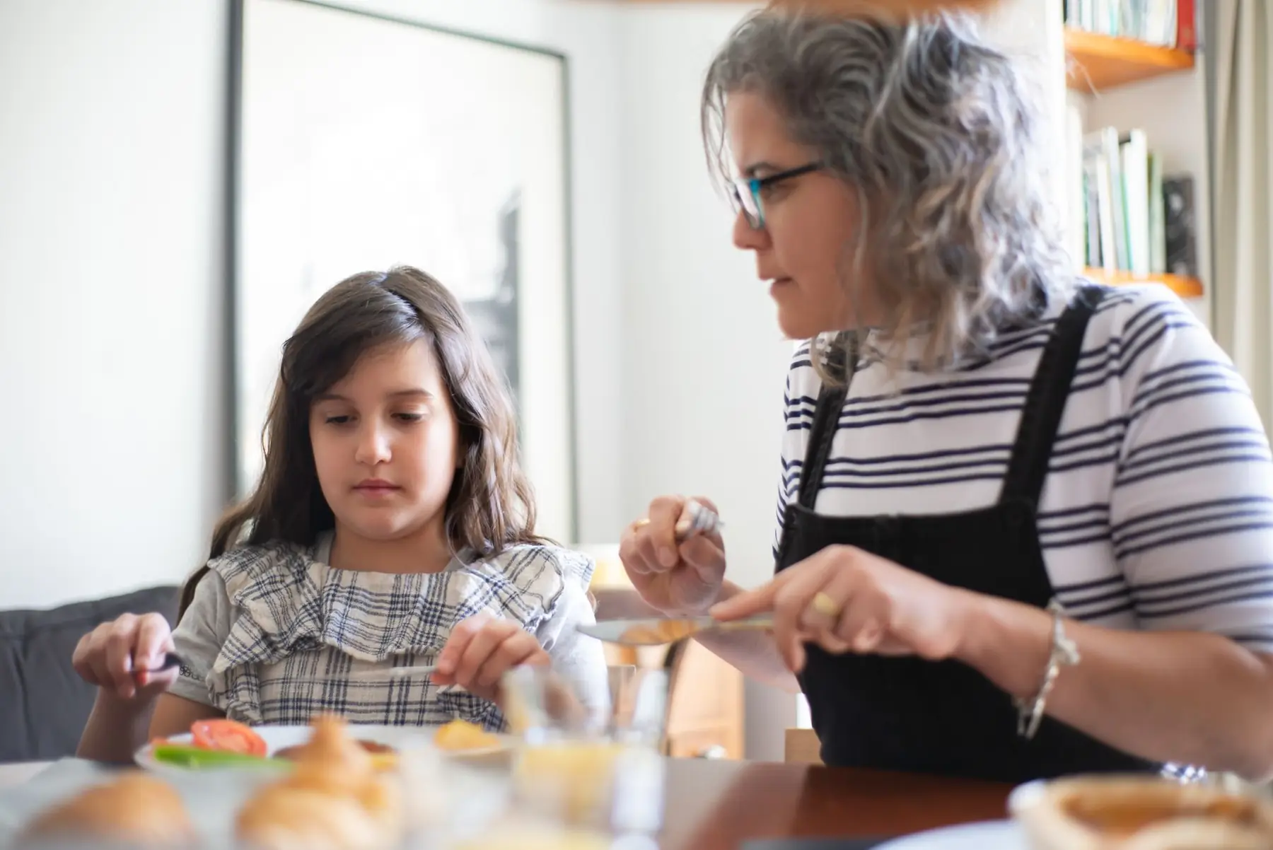 A mother and daughter enjoying quality time together at the dining table during the