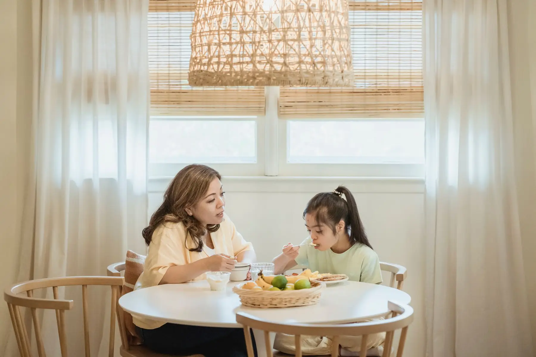A mother and daughter sharing a breakfast meal at a cozy home dining table