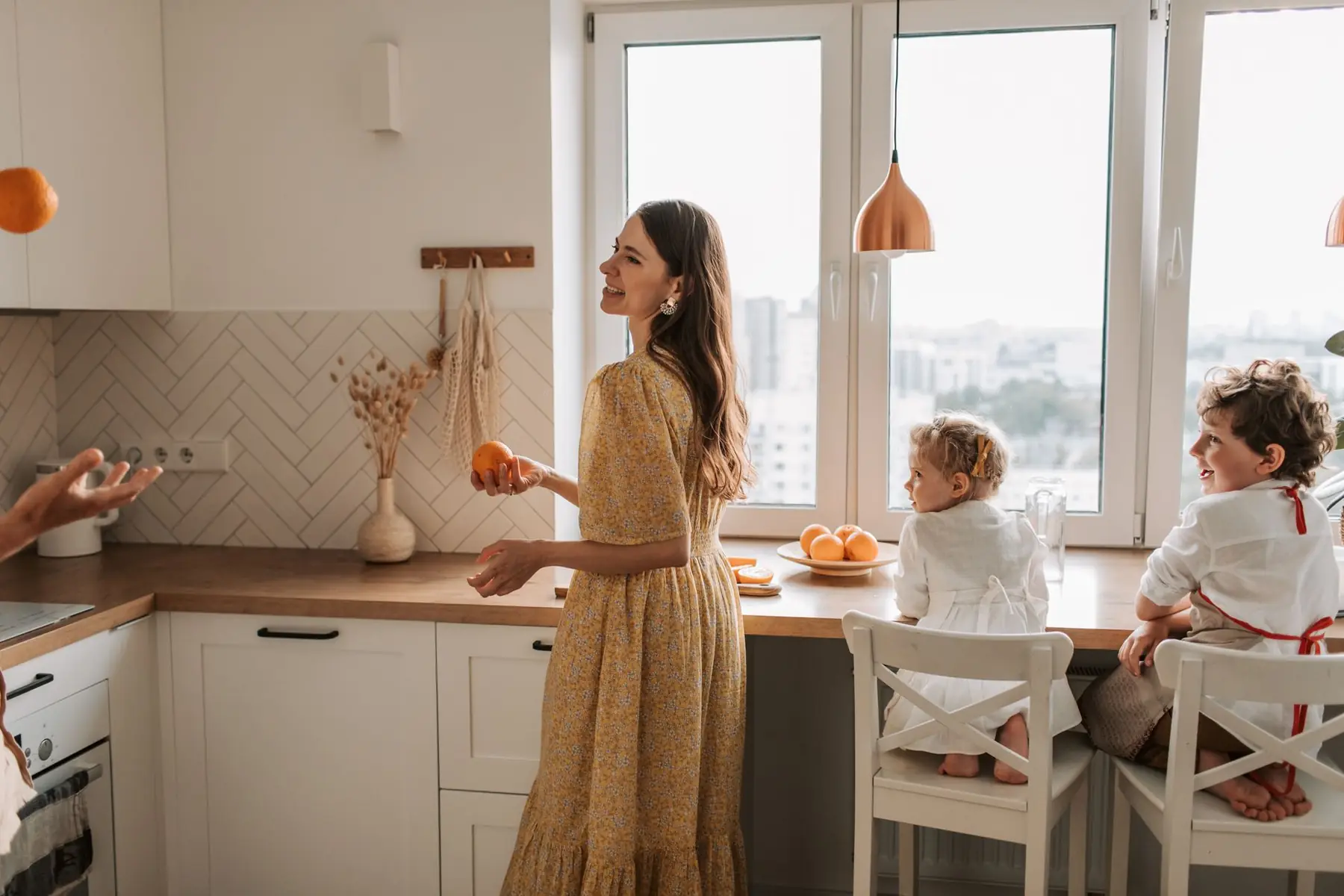A joyful family bonding in a bright kitchen with oranges and smiles