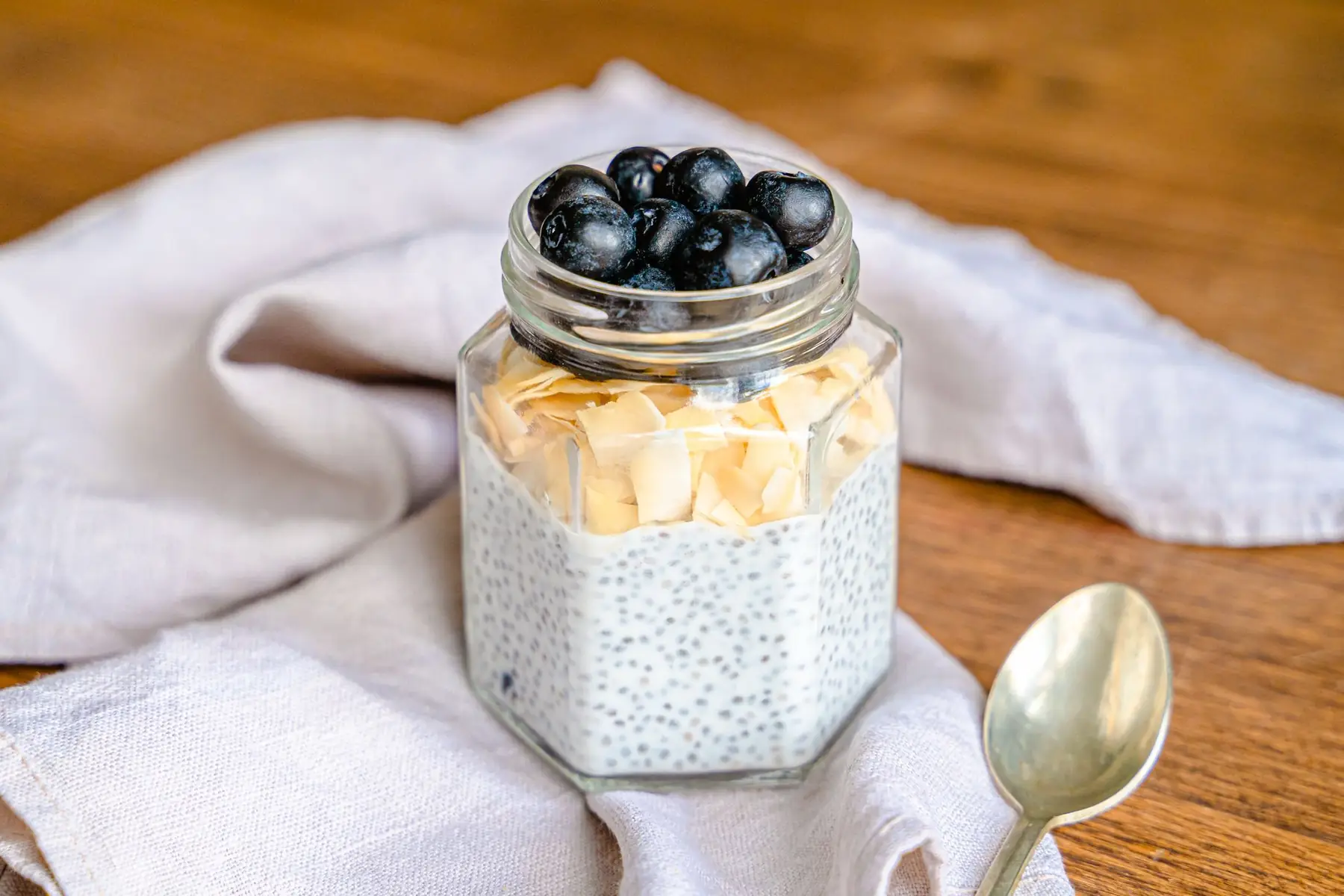 Delicious chia pudding topped with blueberries and almond flakes in a jar