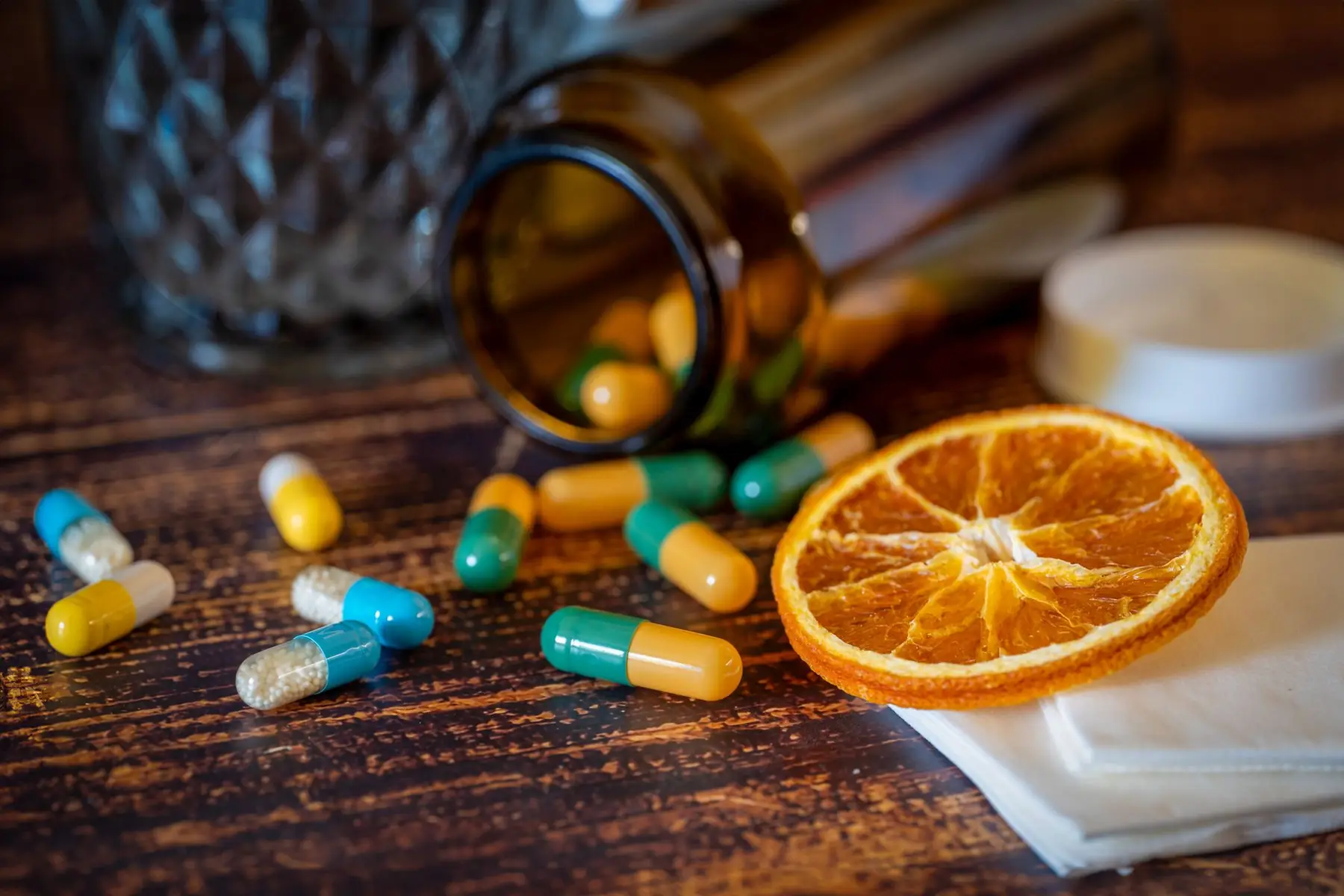 Close-up of vitamins, pills, and dried orange slice for cold relief