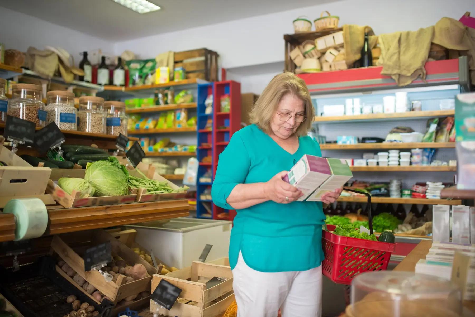 An elderly woman examines a product in a grocery store in Portugal