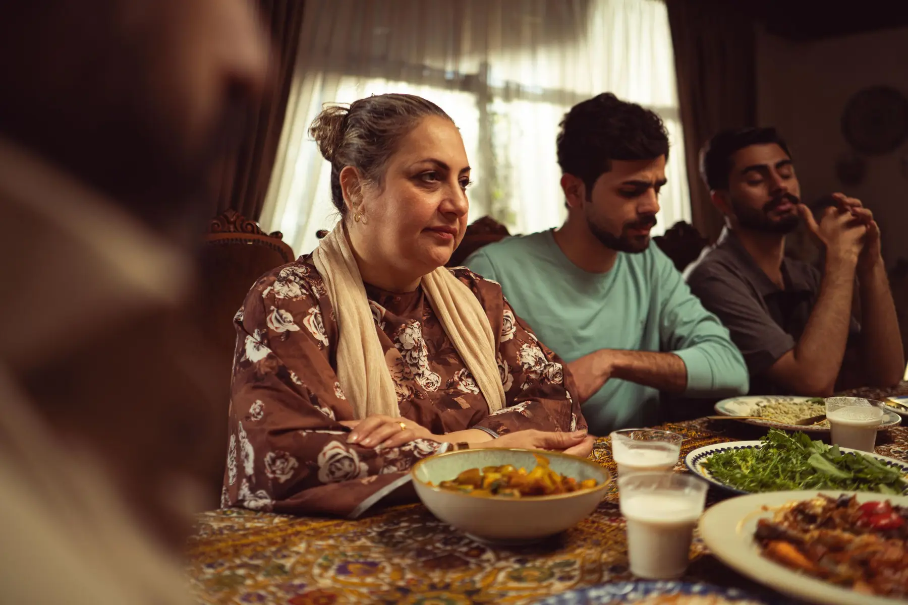 A family shares a warm dinner around a table