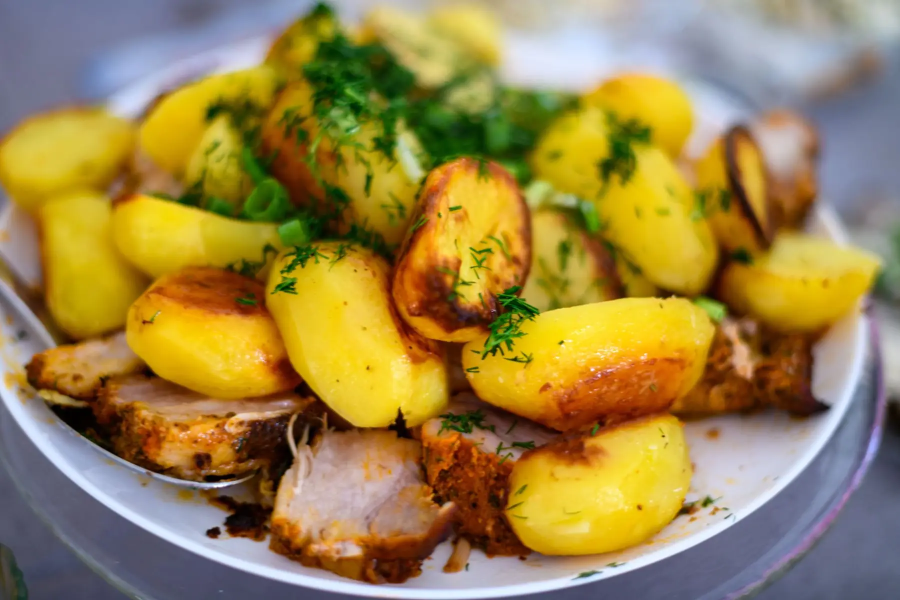 Delicious roasted potatoes and meat garnished with fresh dill, perfect for a hearty meal