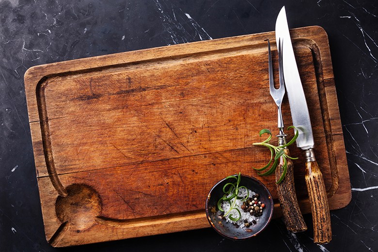 Cutting board with cutlery, rosemary and spices