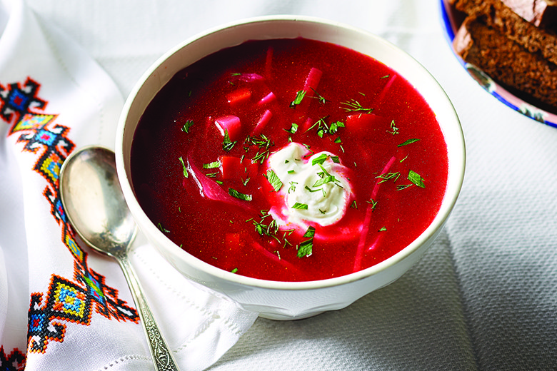 Bowl of borscht on white background